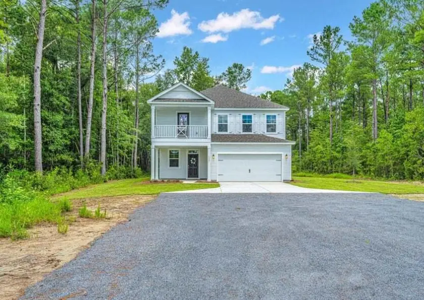 a house with a driveway and trees