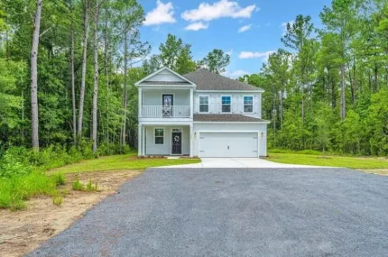 a house with a driveway and trees